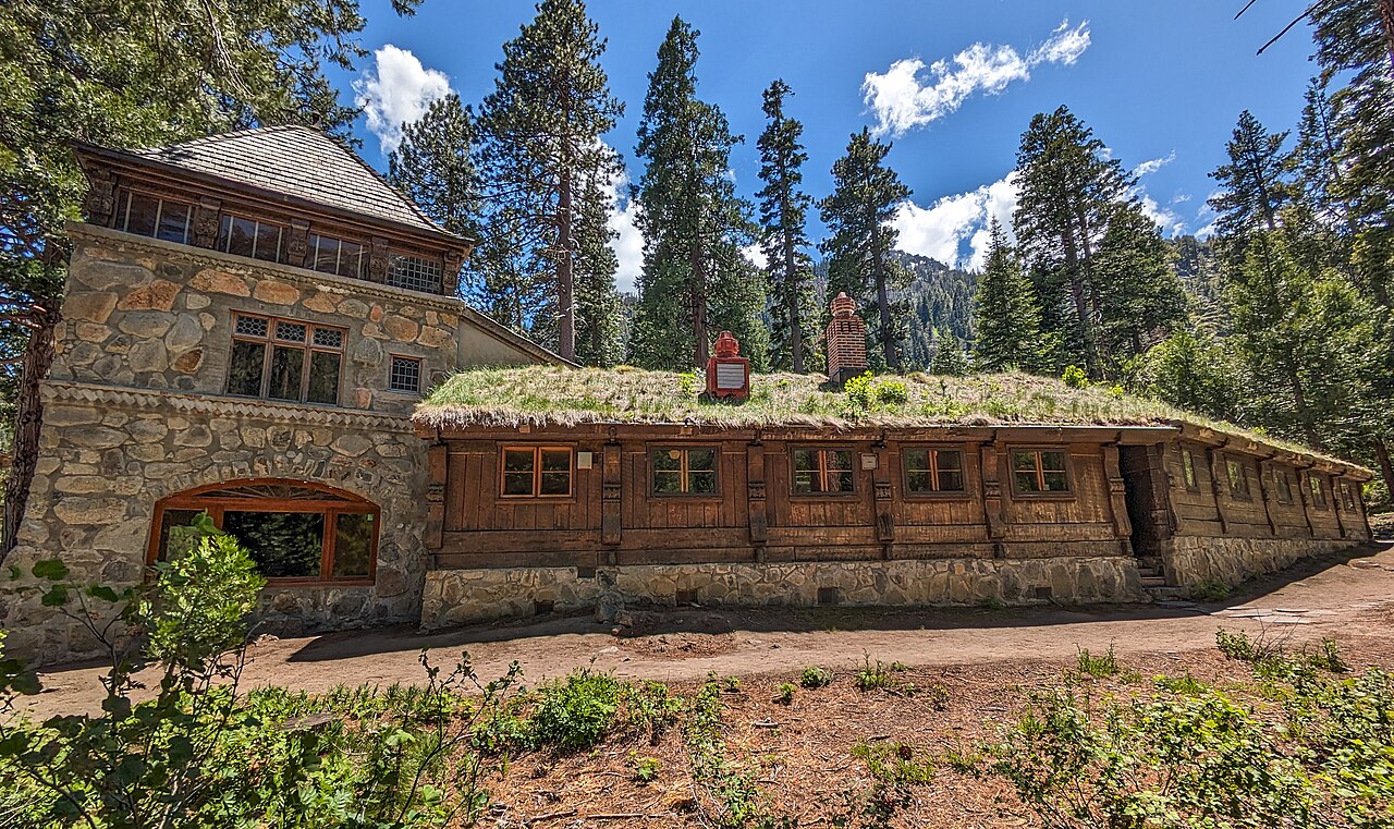 Vikingsholm stone tower and timber wing with a sod roof beneath pine trees